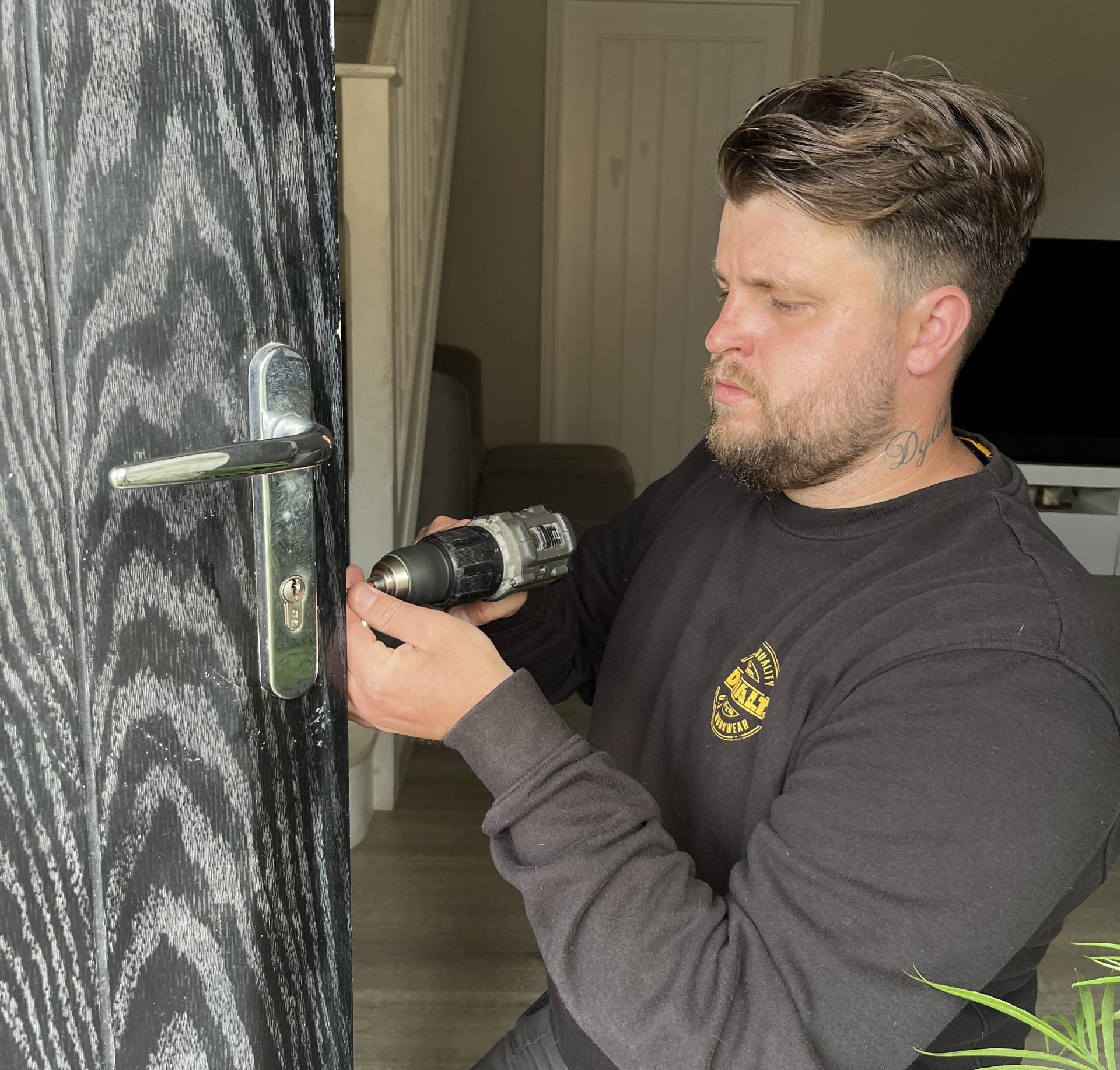 Connor from Seymour Locksmiths using a drill while fitting a lock on a front door